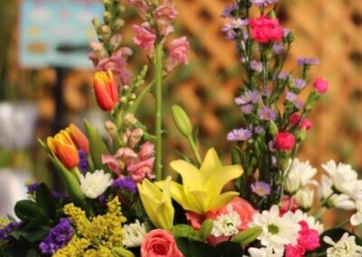 Floral basket with snapdragons, roses, and colorful flowers.