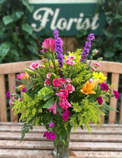 Floral vase with pink, purple, and yellow flowers.