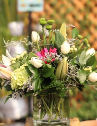 Floral arrangement in a square vase with pink and white flowers.