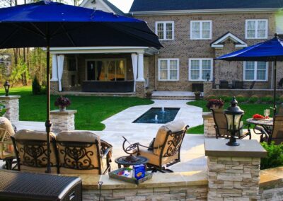 poolside patio with outdoor furniture and blue umbrellas