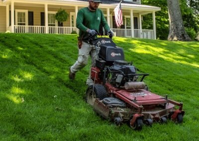 cross creek employee mowing the lawn with perfect stripes