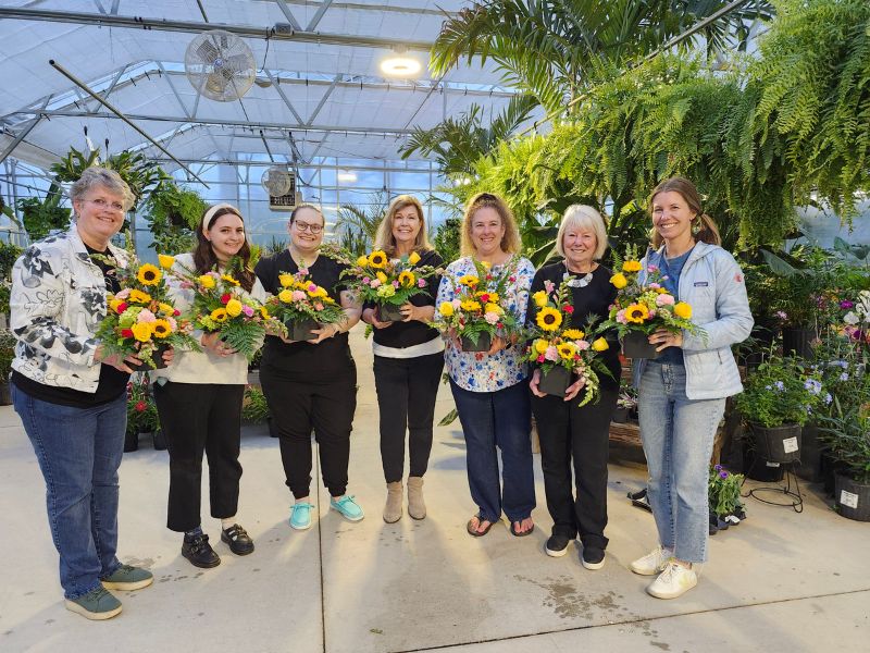 west-end-floral-design-wine group of women holding custome sunflower deisgn photos